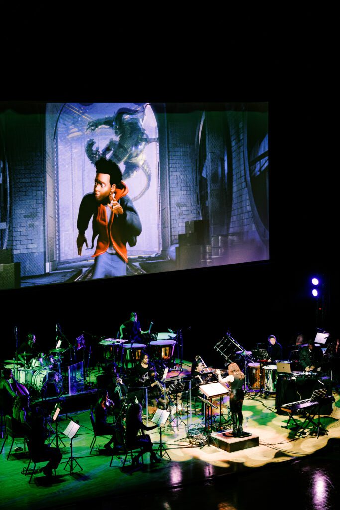 Broadway Sinfonietta, an all-female orchestra follows along with the conductor as scenes from the movie, "Spider Man: Into the Spider-Verse", plays behind them on a large screen.