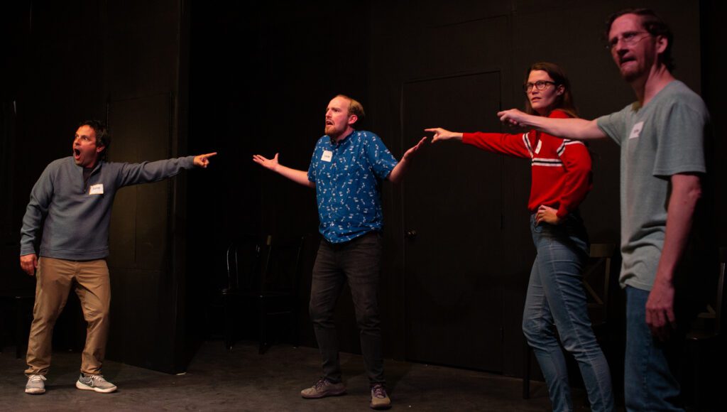 From left, Chris Cano, Daniel Repp, Mädchen Petrie and Seth Thomson perform on stage as they all point to Daniel Repp during the performance.