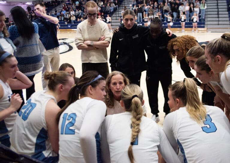 Western head coach Carmen Dolfo talks to her team as she is surrounded by all members.