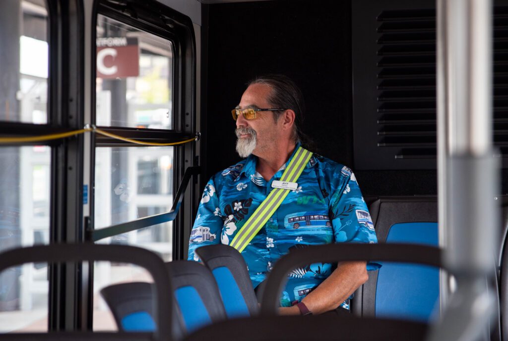 Jeff James looks out the window while sitting in the back left corner of the bus.