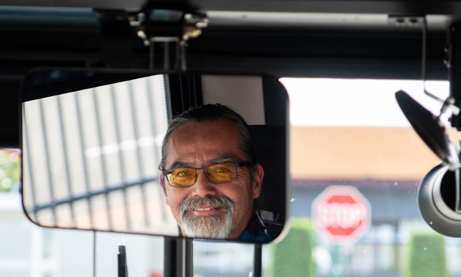 In the rear view mirror, Jeff James is smiling at the camera.