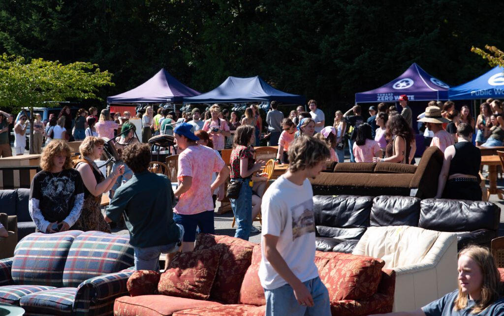 Crowds of visitors look over the various couches and furniture up for grabs.