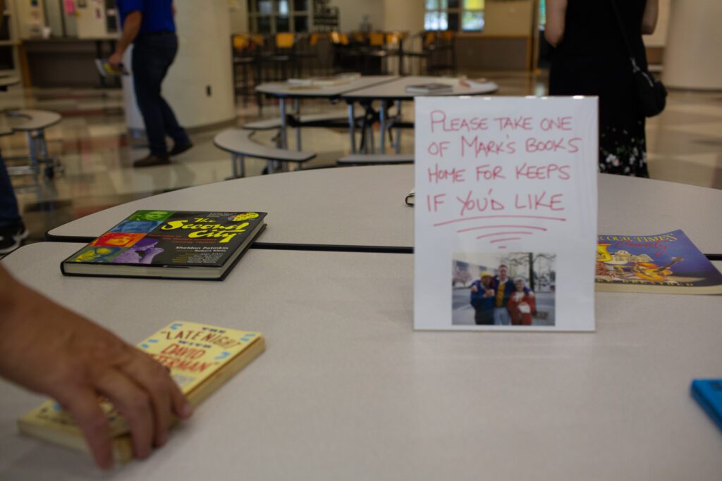 Mark Scholten's books on a table with a white sign letting the visitor know to take Mark's books if they wanted to.