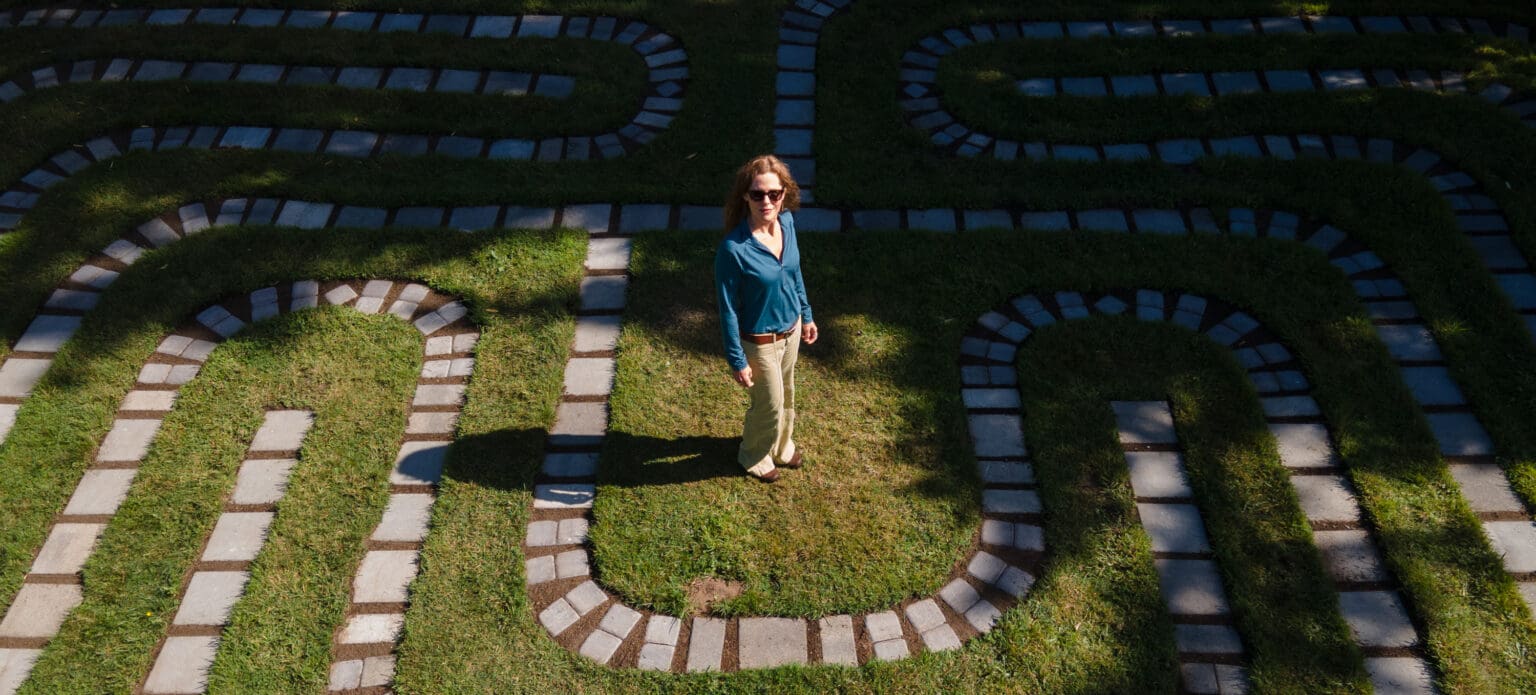 Kristen Winn stands in the middle of the labyrinth she built at the Bow Sanctuary where the path is lined with stepping stones to show the path.