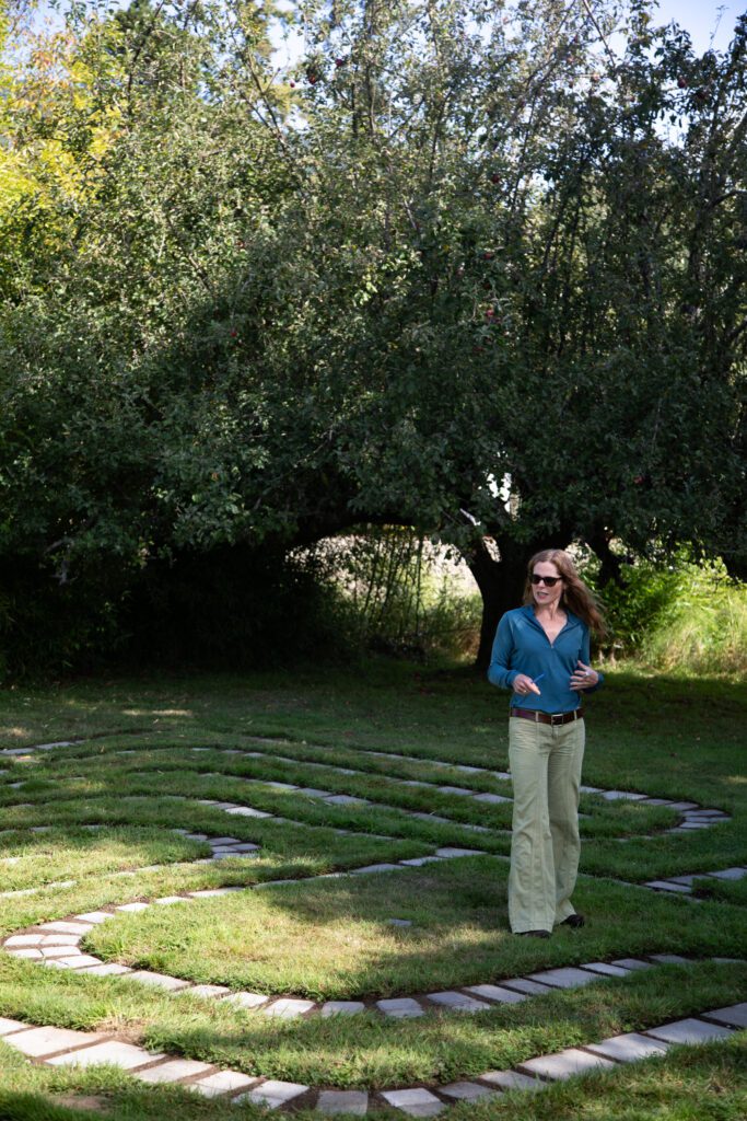 Kristen Winn stands at the center of the labyrinth as she talks and gestures with her hands.