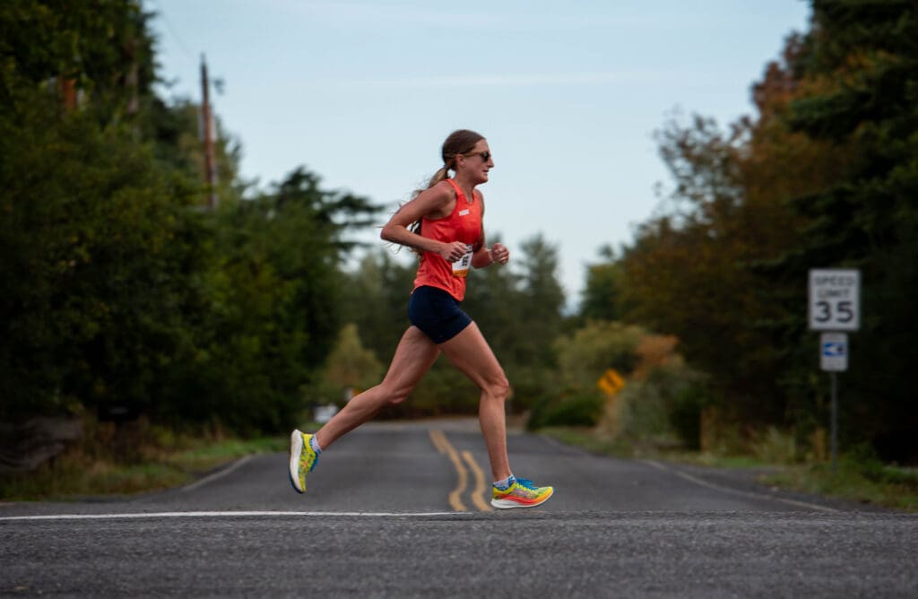 Courtney Olsen runs through an intersection on Country Lane wearing a bright red tanktop.