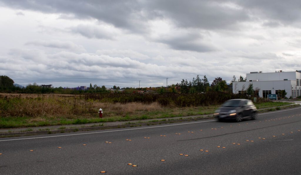 A car drives by near the Peace Health building.