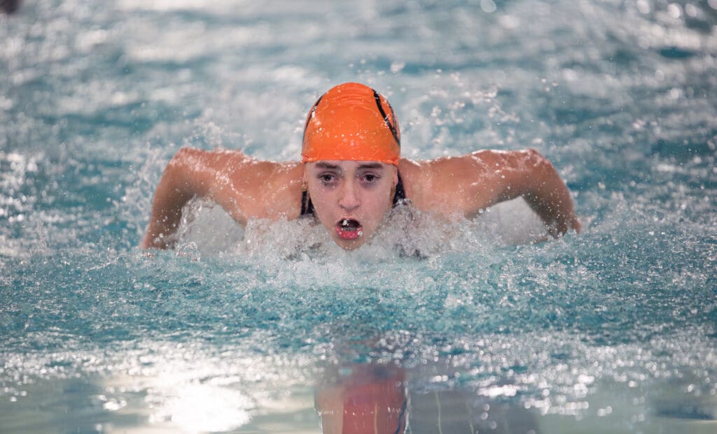 Hailey Ferrell takes a breath as she propels herself forward with water splashing all around her.