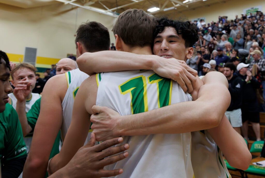 Lynden’s Anthony Cananles hugs Ty Hollerman after Hommerman’s last second basket won the game for the Lions, 64-62 over Anacortes.