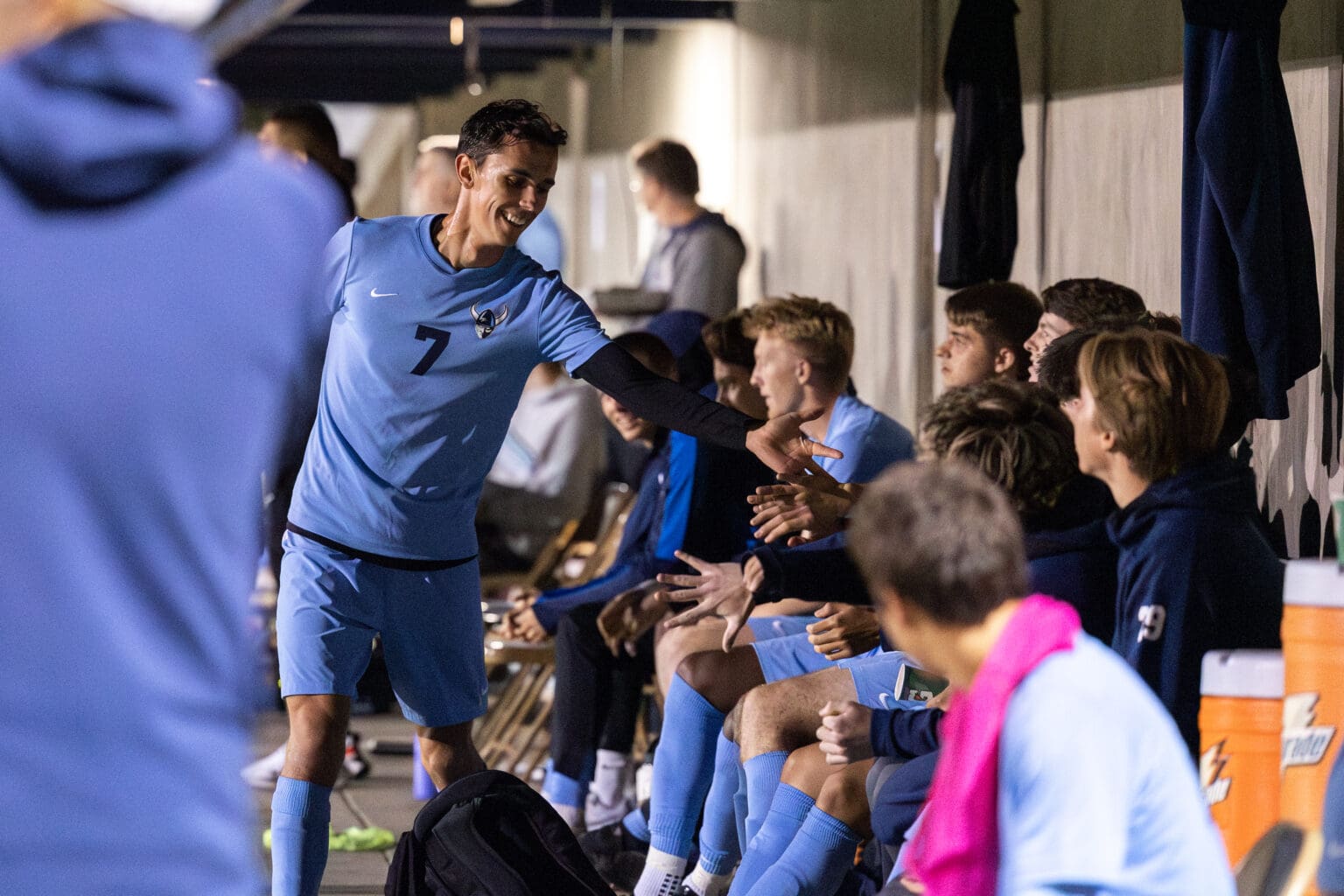 Albin Jonsson runs along the sidelines to high-five benched teammates.