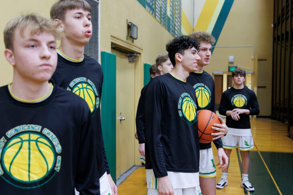 Lynden’s Anthony Cananles talks with teammate Jack Stapleton before the Lions take on Anacortes on Wednesday.