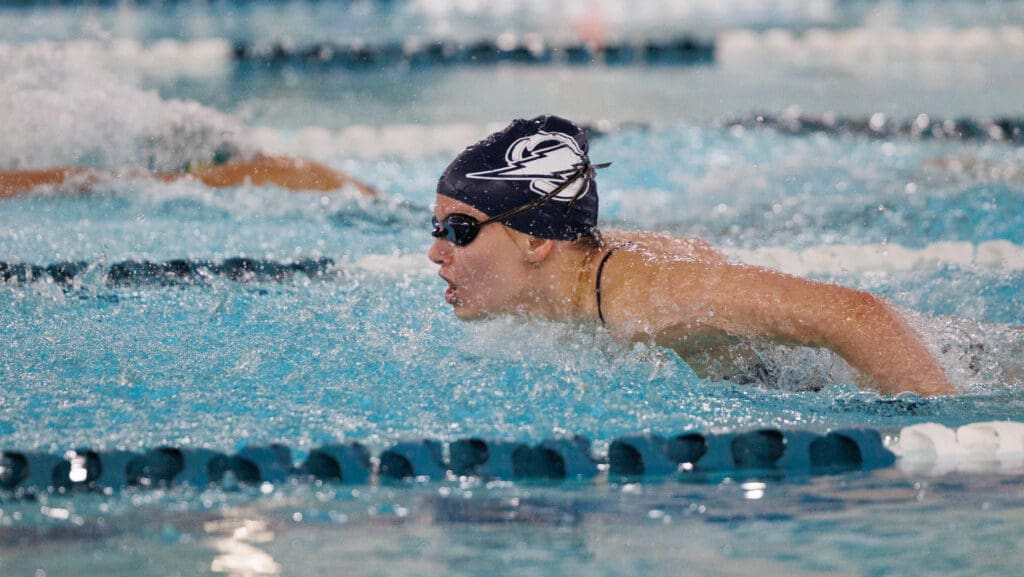 Ariel Fuhrman swims the butterfly leg of the 200-yard individual medley as she breaches from the water for a breath while water splashes around her.