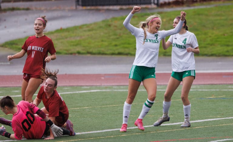 As Cedarcrest players collide, Lynden players celebrate with their arms up high.