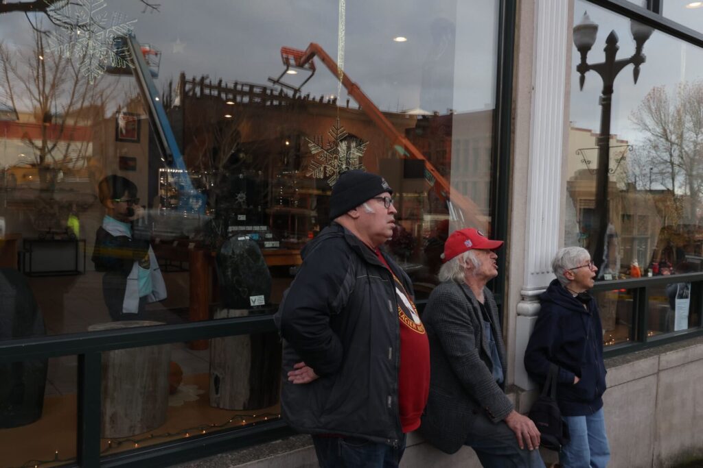 Tom Ekman, left, and Mike O’Donnell watch with their backs to the large windows behind them.