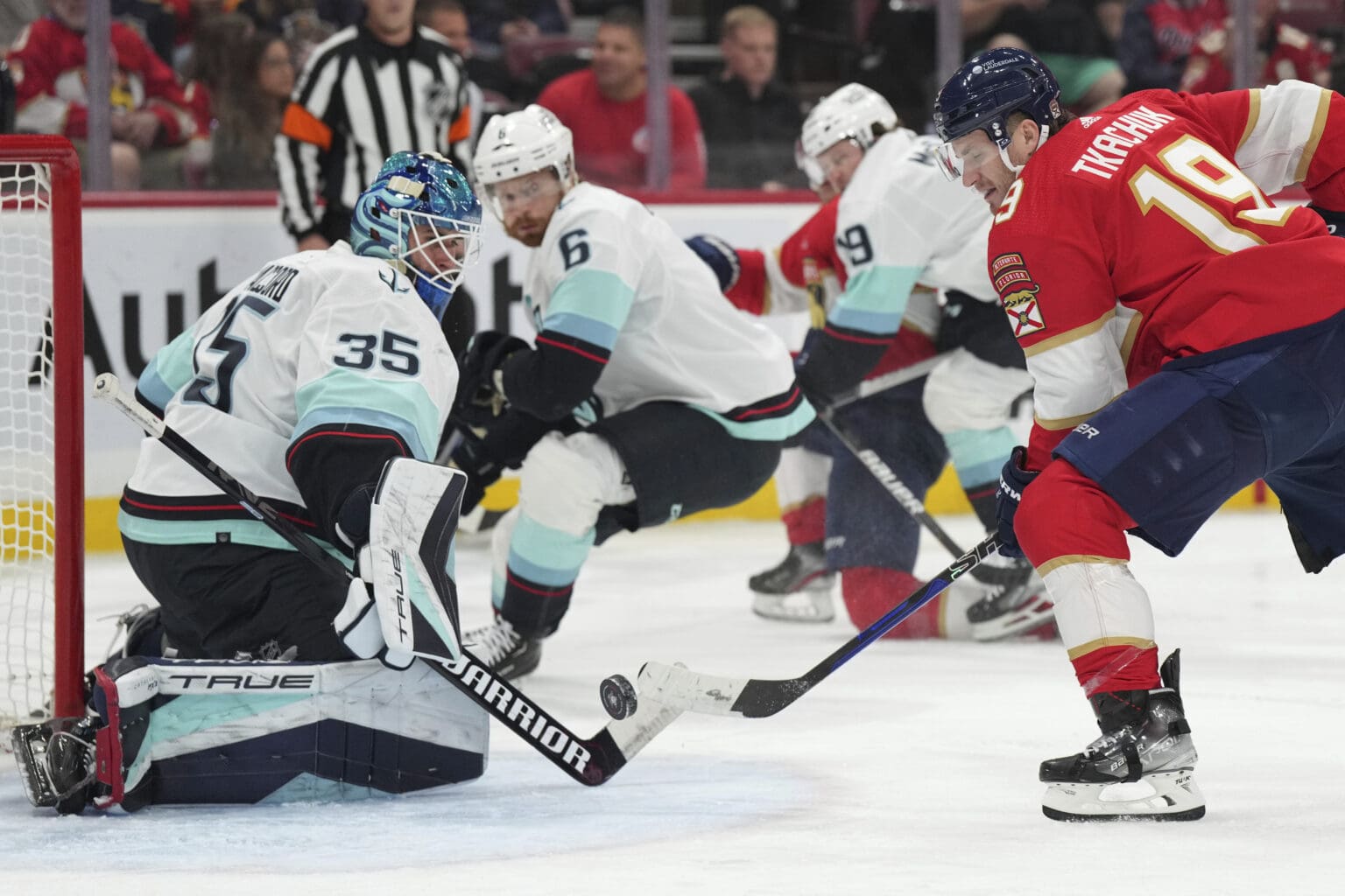 Florida Panthers left wing Matthew Tkachuk (19) tries to get the puck past the goaltender who is kneeling to block the shot.