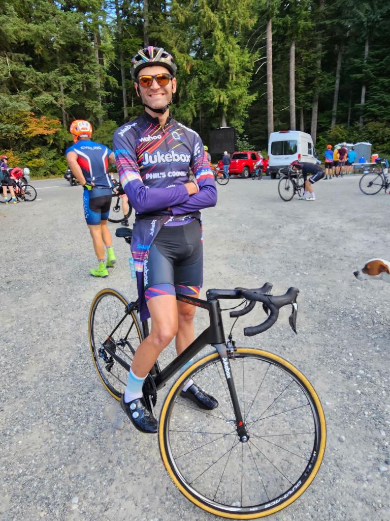 Phil Gaimon, a two-time hillclimb world champion and 2017 USA Cycling Hillclimb national champion smiles for the camera with his arms crossed.