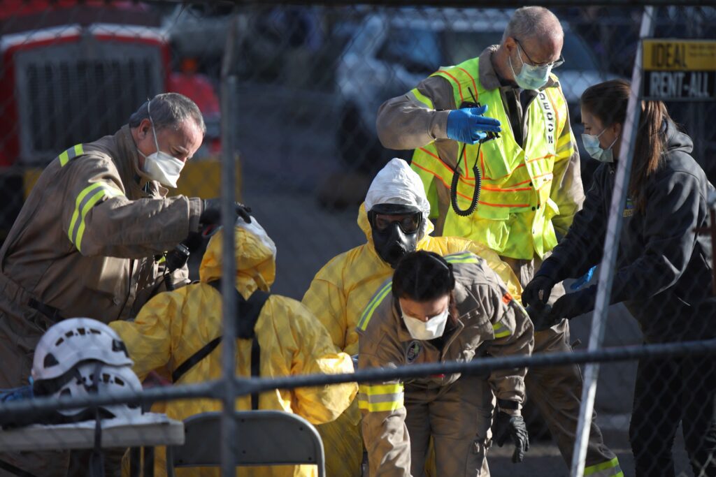 Investigators remove their hazmat suits during a break.