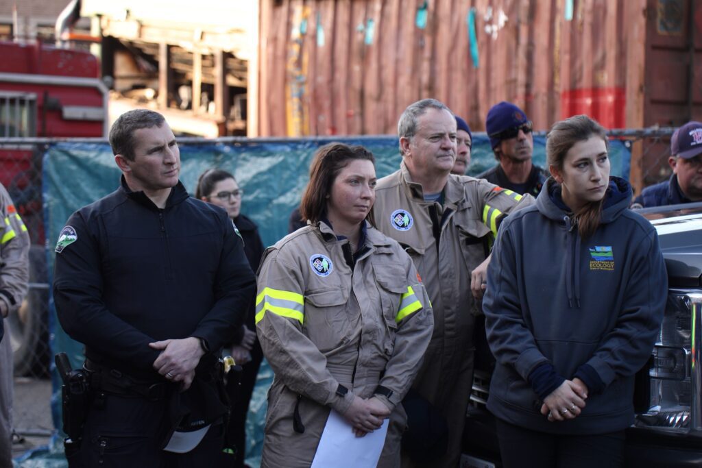 Responders from the Bellingham Police Department, Hazmat Response and the Washington State Department of Ecology listen to praise and appreciation from Nate Breaux's parents, Belinda and Randy Breaux.