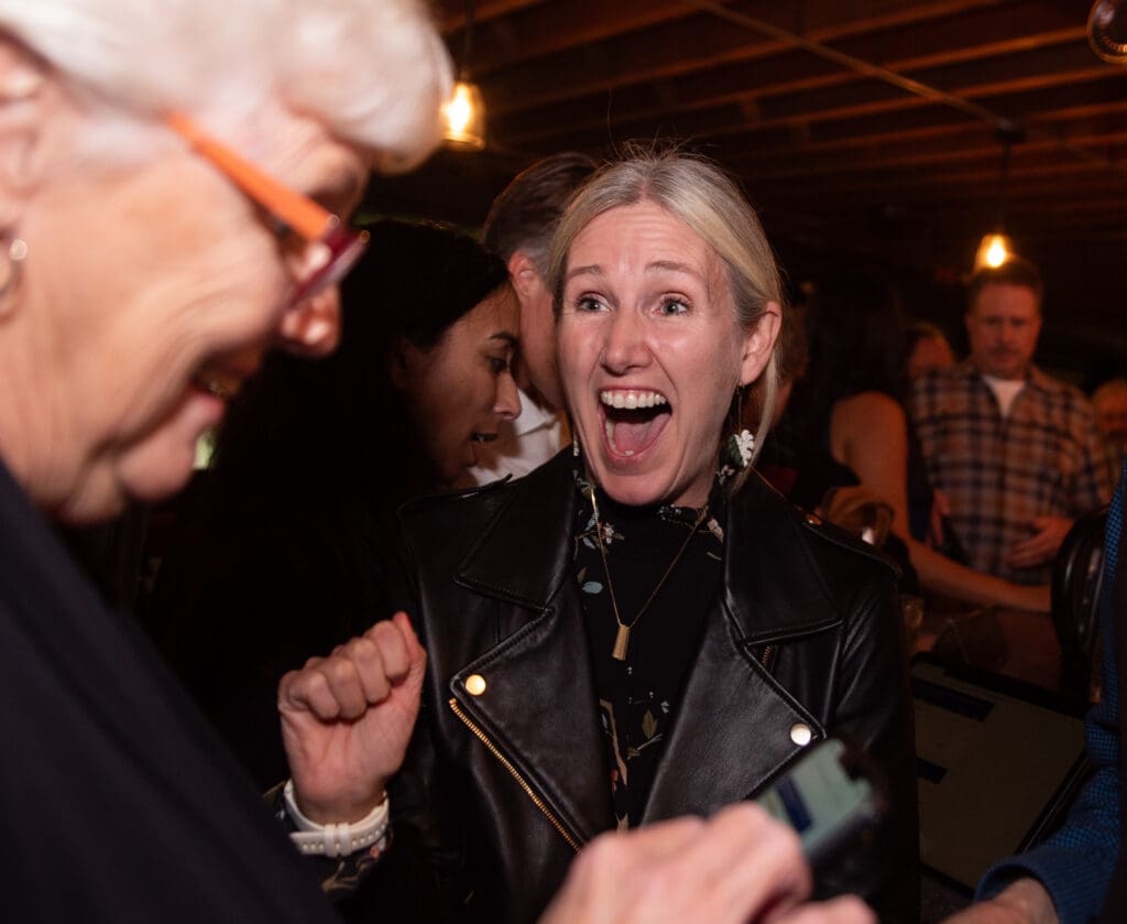 Incoming mayor of Bellingham Kim Lund reacts to the slim margins in the mayoral race read out loud by an older woman.