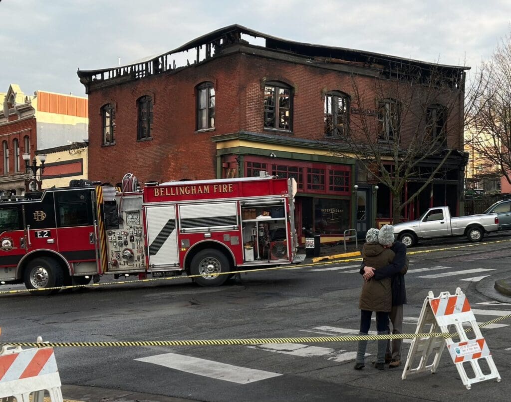 Pat Wickline and Sharon Streams hug near a firetruck.