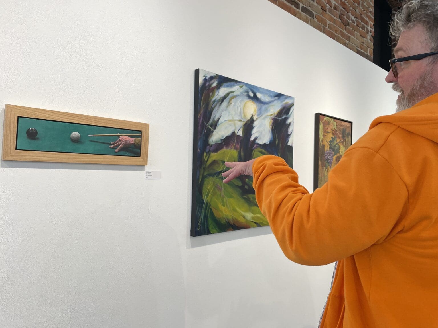 An attendee gestures to an exhibit entry.