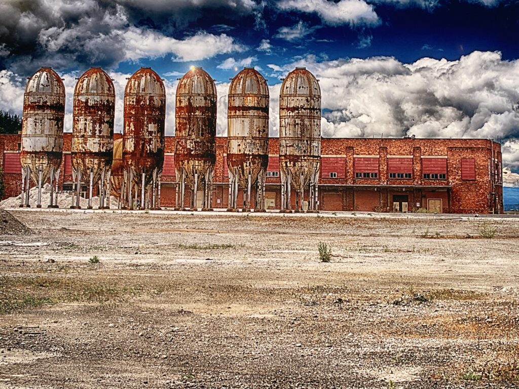 Tommy Gibson's “Bellingham Rockets” photograph features the six rusty digester tanks on the city’s waterfront with large clouds looming behind the building.