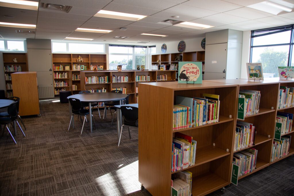 Shelves of books surround tables and chairs.