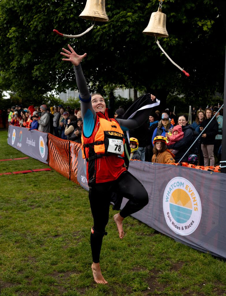 Car free Green Mountain PT kayaker Ana Swetish jumps for the bell at the finish line.