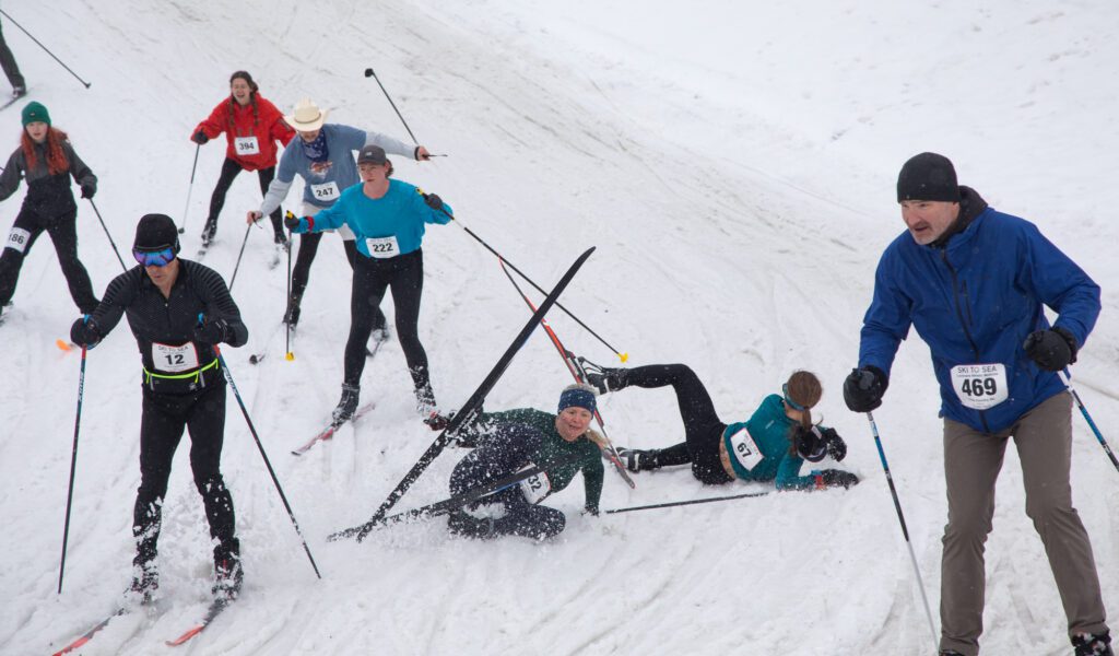 Meagan Sullivan, of Ludicrous Speed, crashes trying to avoid running over Jeanie Pflueger of the Ski to Sea Sissies on a downhill turn. Parts of the ski course were treacherous, leading to many crashes.