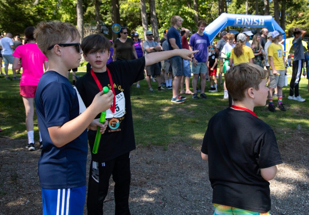 Teammates from Beavers Tree Service – 3rd Grade watch the middle and high school race.