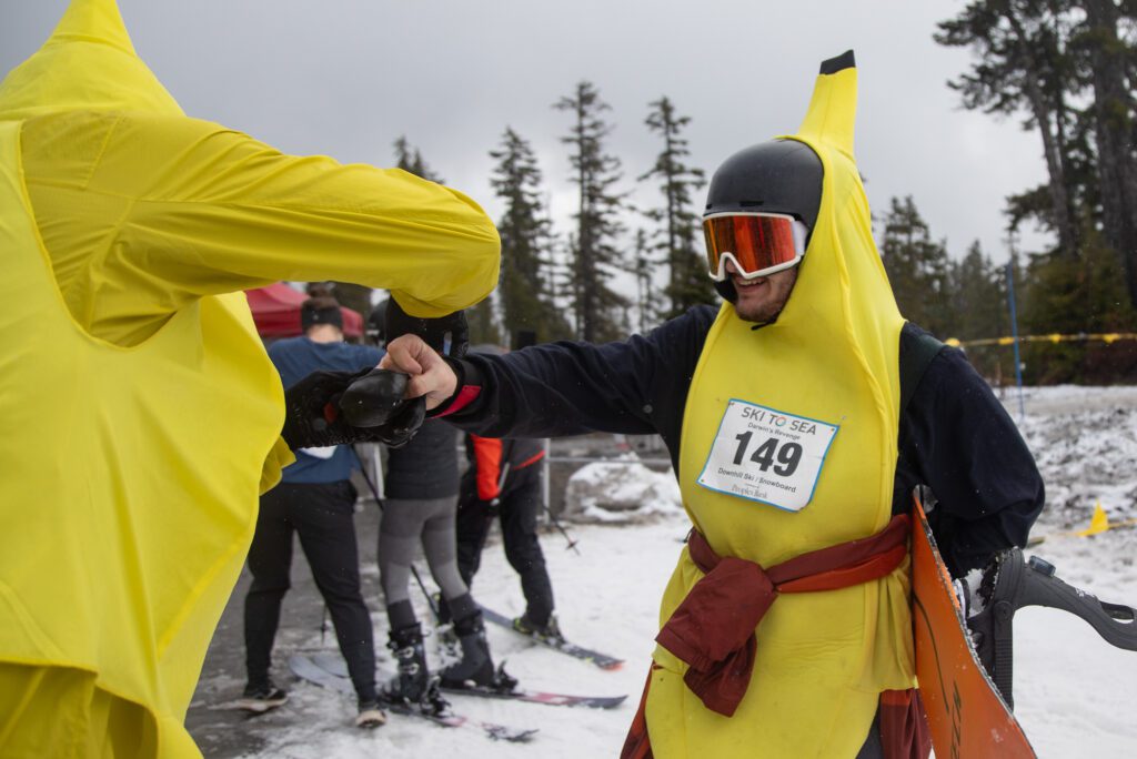 Dylan Price, of team Darwin’s Revenge, hands the timing chip to teammate Sam Luedloff. “Please take it, I don’t want this f—ing thing anymore,” Price said, laughing.