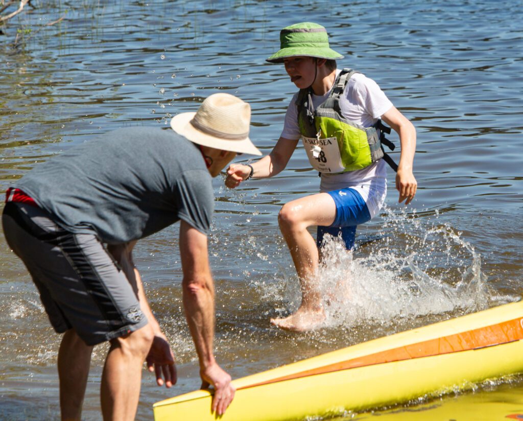 Liam Spaulding of Skibity Squad high steps out of the water after finishing the kayak leg. His team placed first in the middle school male division with a time of 1:10:10.