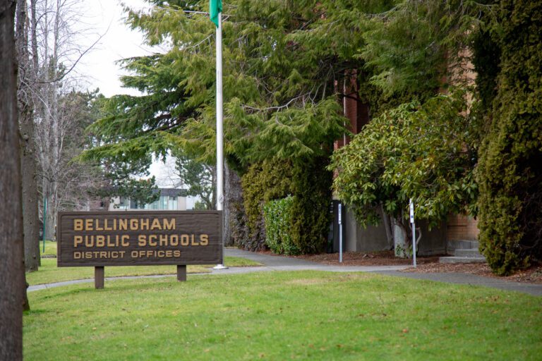 Three Bellingham Public Schools district office has a large wooden outdoor sign in front of the entrance.