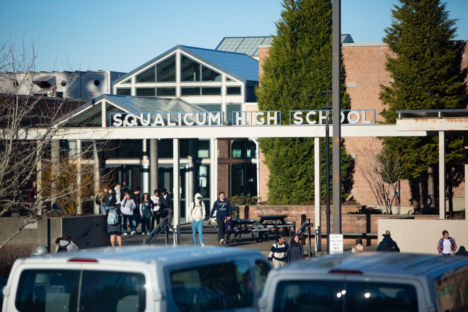 The front of Squalicum High School has students filter out from the main entrance.