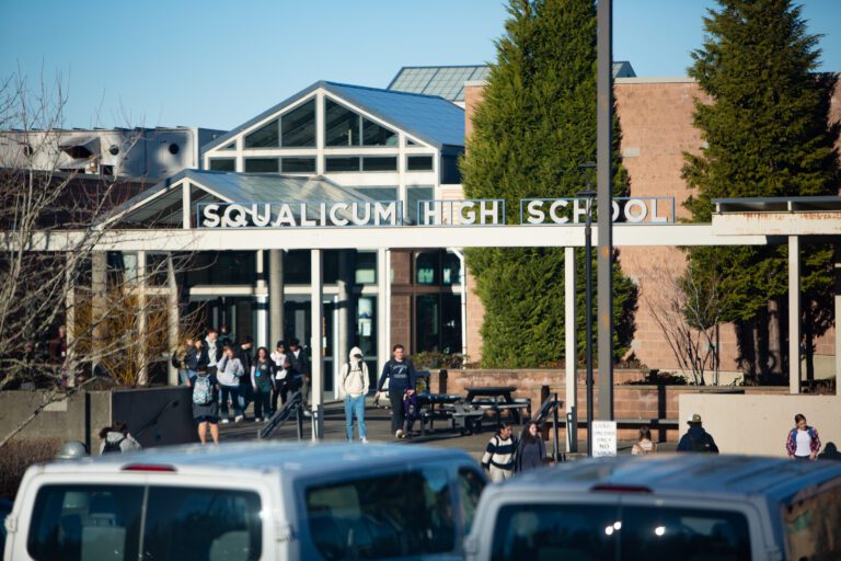 The front of Squalicum High School has students filter out from the main entrance.