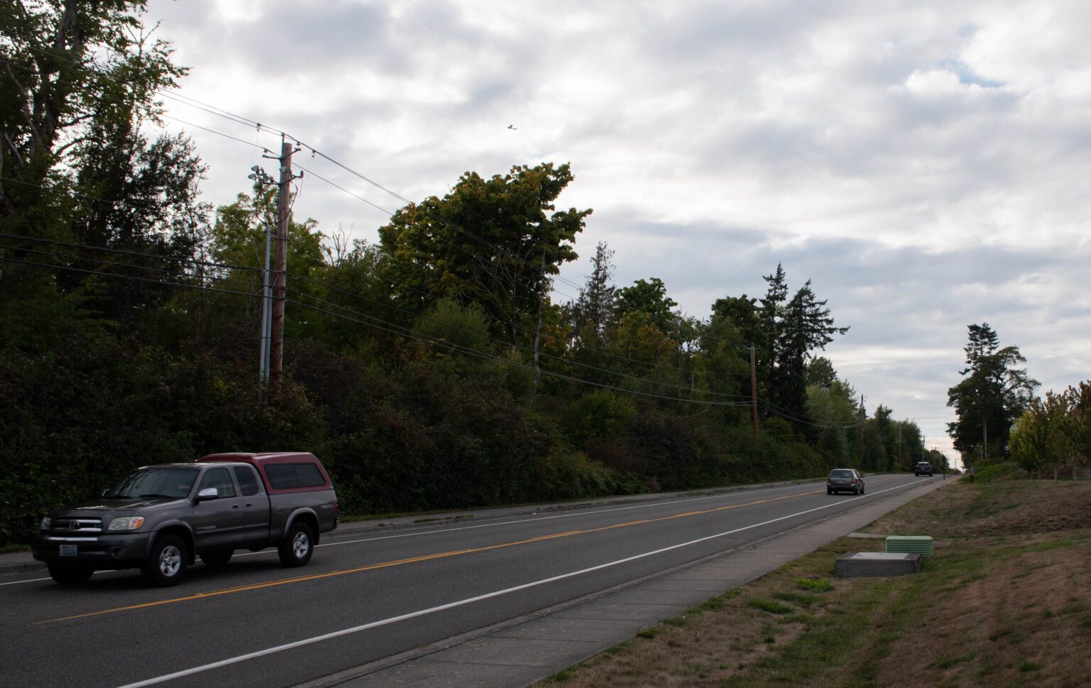 Cars drive along the road past the site of the proposed metal shredder.