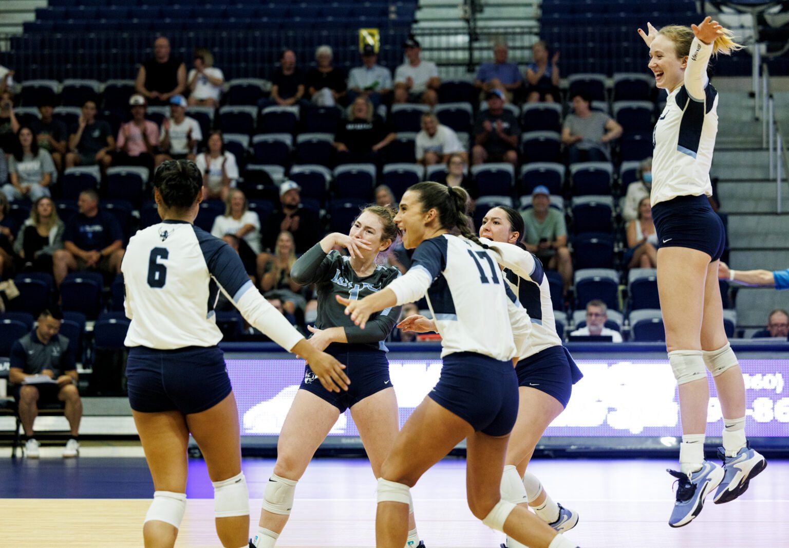 Western Washington University players celebrate after scoring as they leap and rush to hug Malia Aleaga (6) who scored an ace on the first serve.