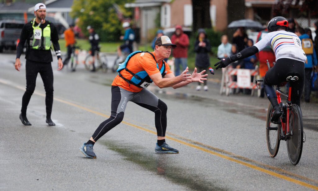 Shek Aven catches the timer thrown by road biker Mike Robson during the canoe leg exchange.