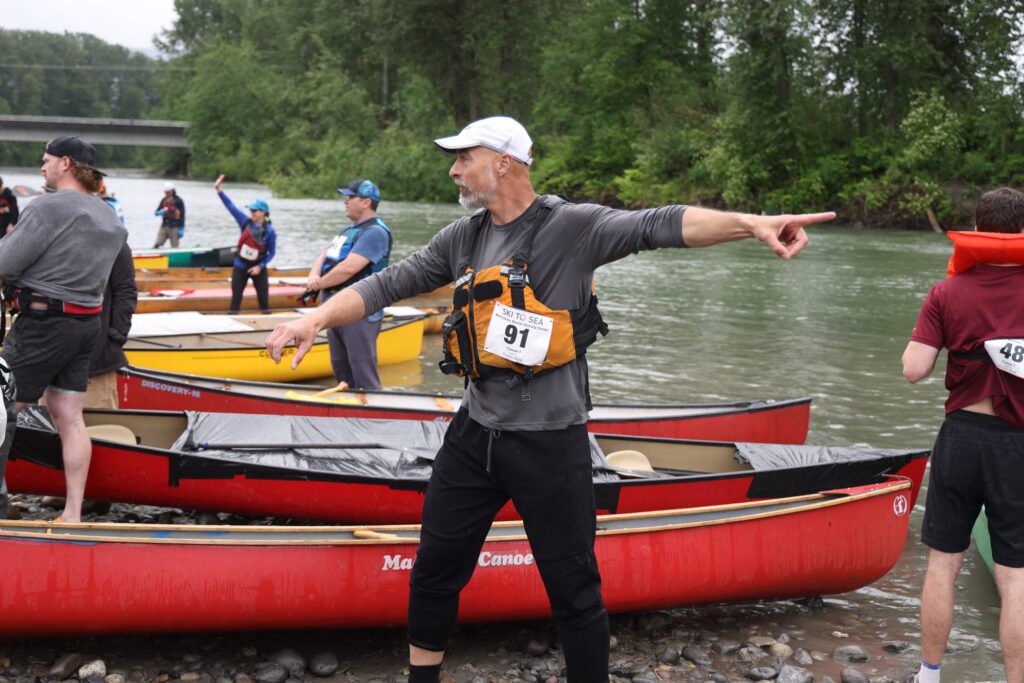 While waiting for his partner to arrive, Brandon Nelson points to boats, directing others to their boats.