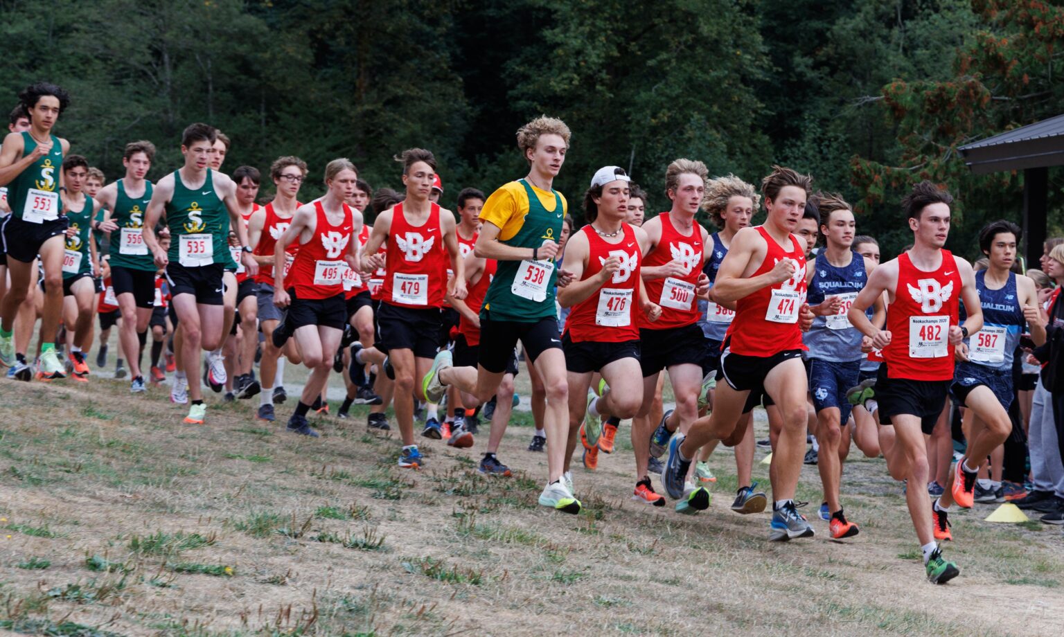 Sehome’s Zack Munson runs ahead of the pack with many groups wearing matching colors to represent their team.