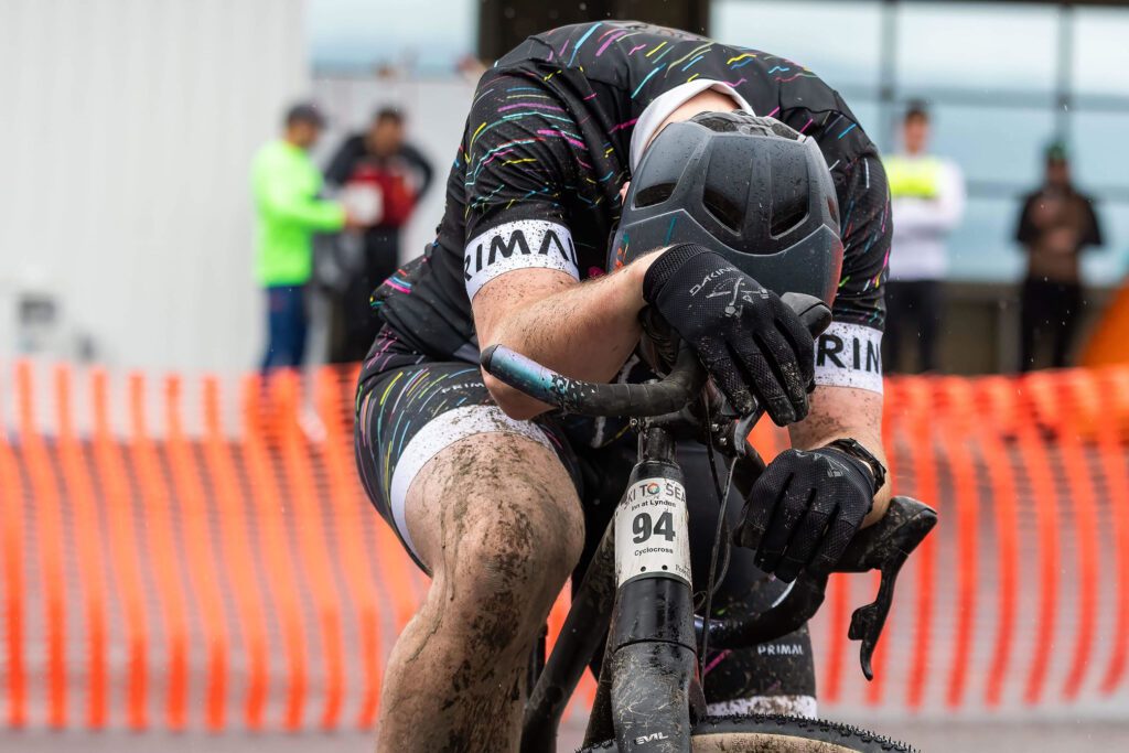 Dylan Bonsell of the Inn at Lynden rests, covered in mud, after the cylcocross leg.