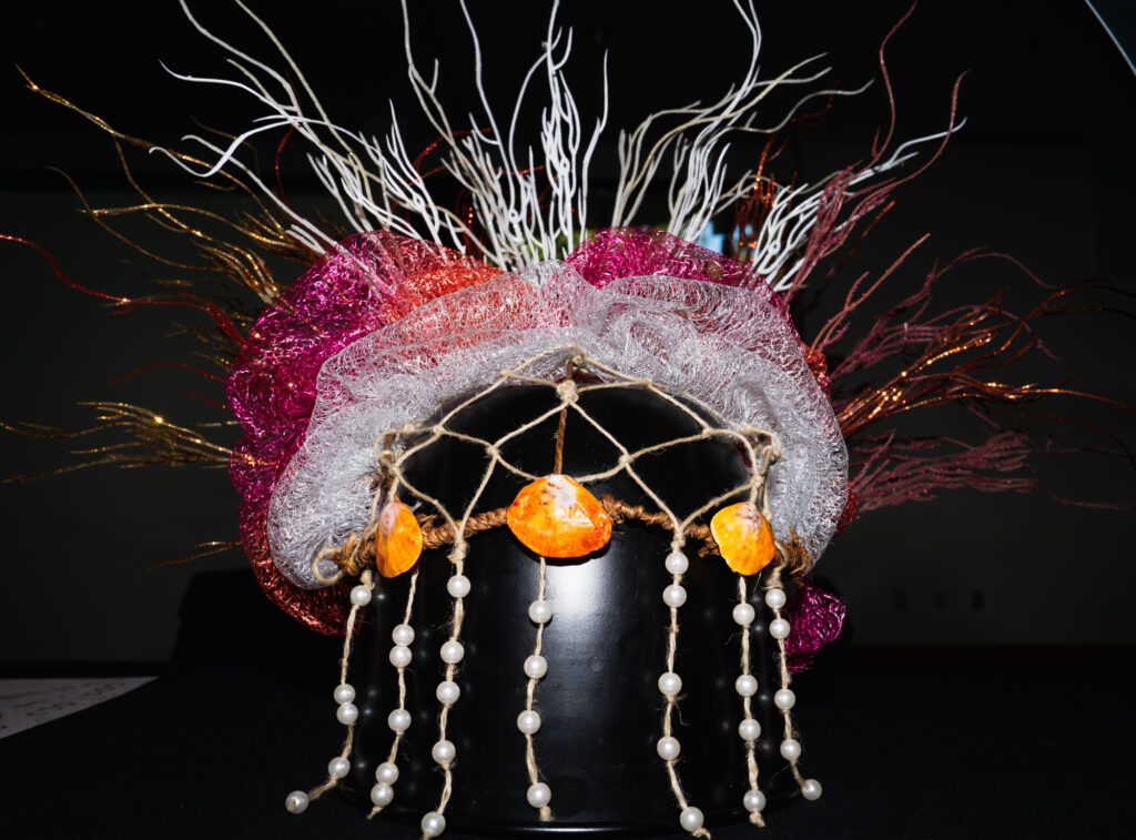 Favio Guzman-Estrada's vibrant head piece was inspired by coral reefs, a vital part of marine ecosystems. Guzman-Estrada uses their art to draw attention to coral reefs, which are facing extinction at the hands of colonial powers and climate change, they said.