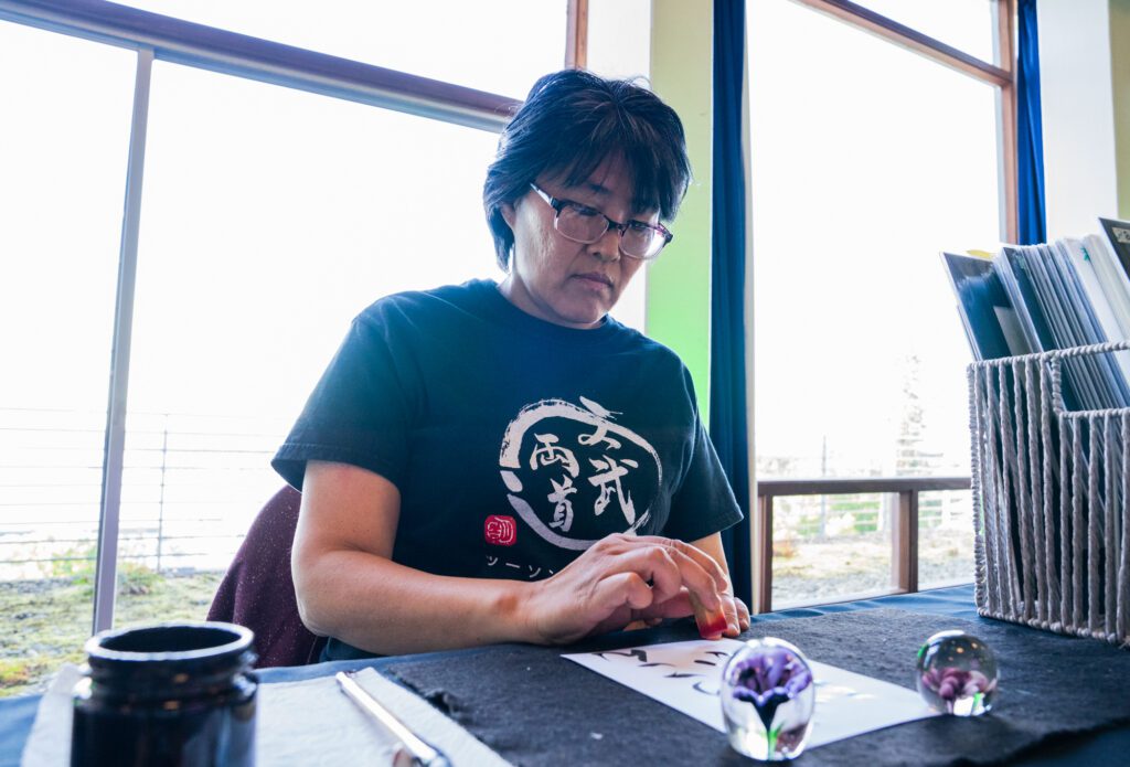 Akiko Victorson takes participants names and writes them in Japanese calligraphy. A practitioner for 40 years, she believes the art form parallels life as there are no do-overs. If you make a mistake, you must move on, Victorson said.