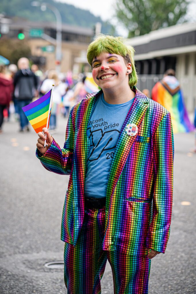 Kade Grossarth, a Whatcom Youth Pride board member, holds a pride flag as the parade loops through downtown Bellingham.