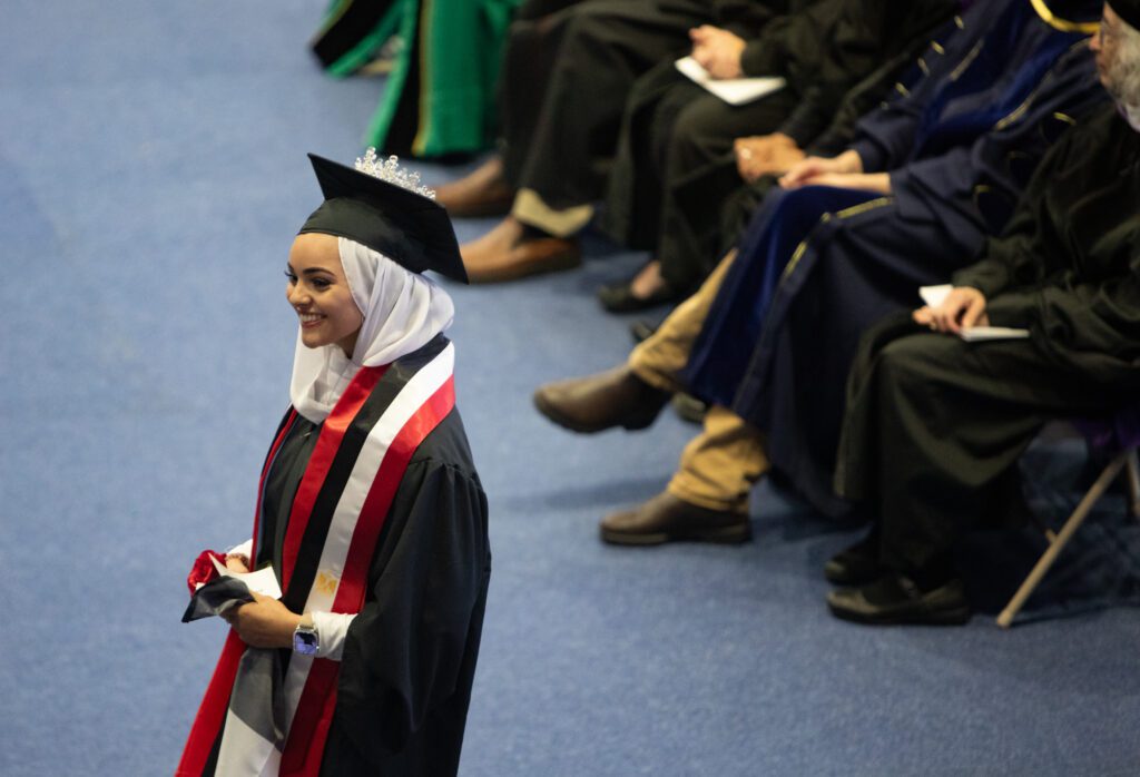 Ameera Abdel-Rassoul smiles big while approaching the stage to receive a degree in communication studies.