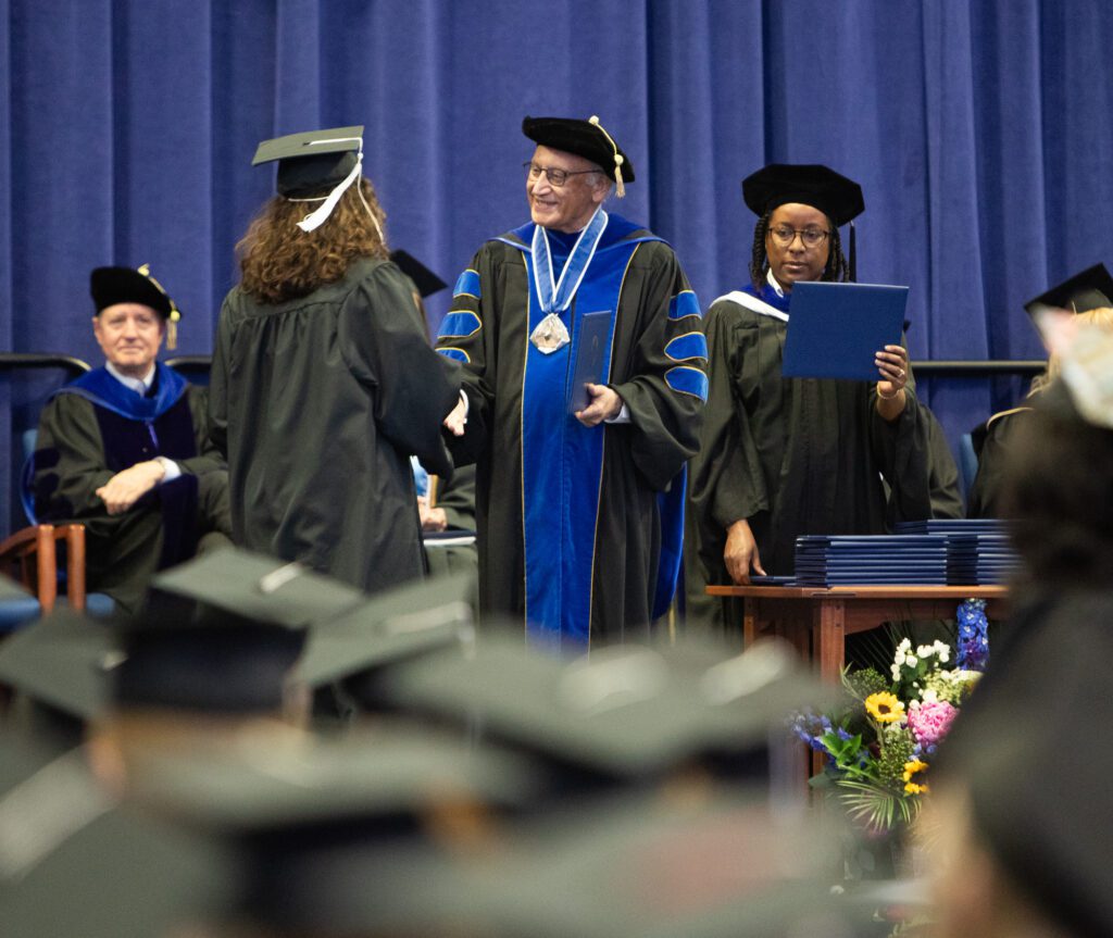 Emma Riffle shakes hands with president Sabah Randhawa.