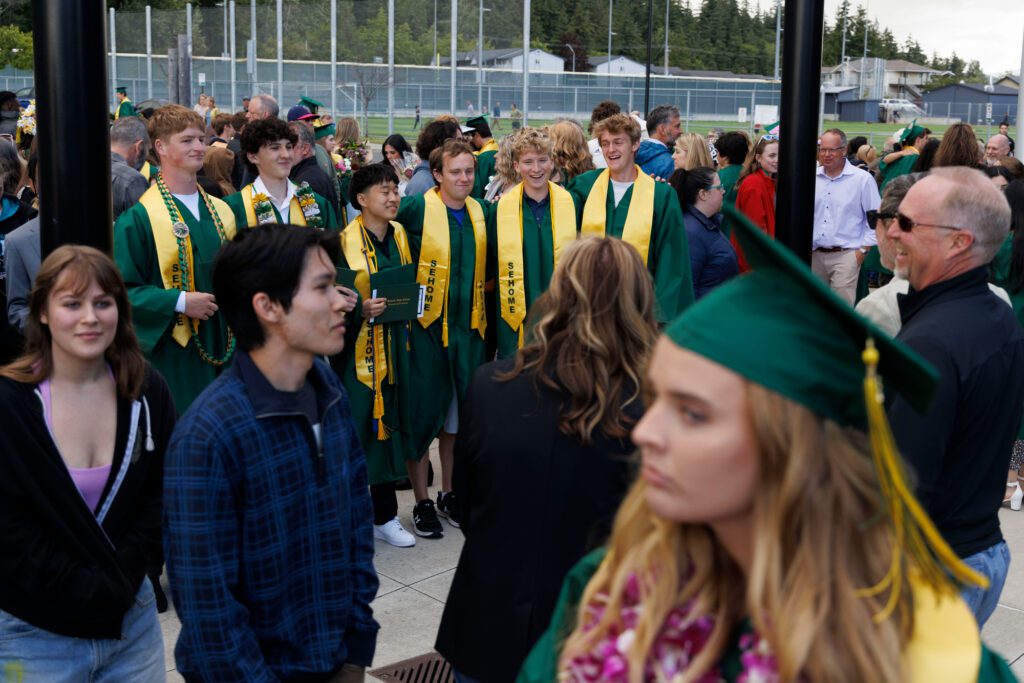 Sehome graduates pose with classmates after their graduation ceremony.