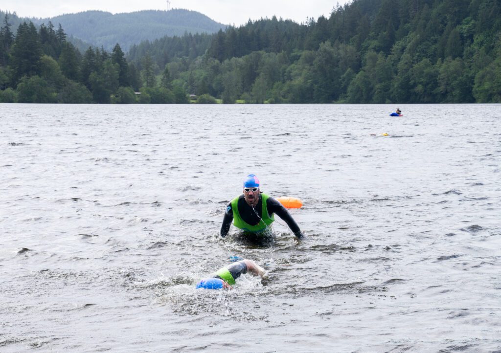 A swimmer emerges from the water.