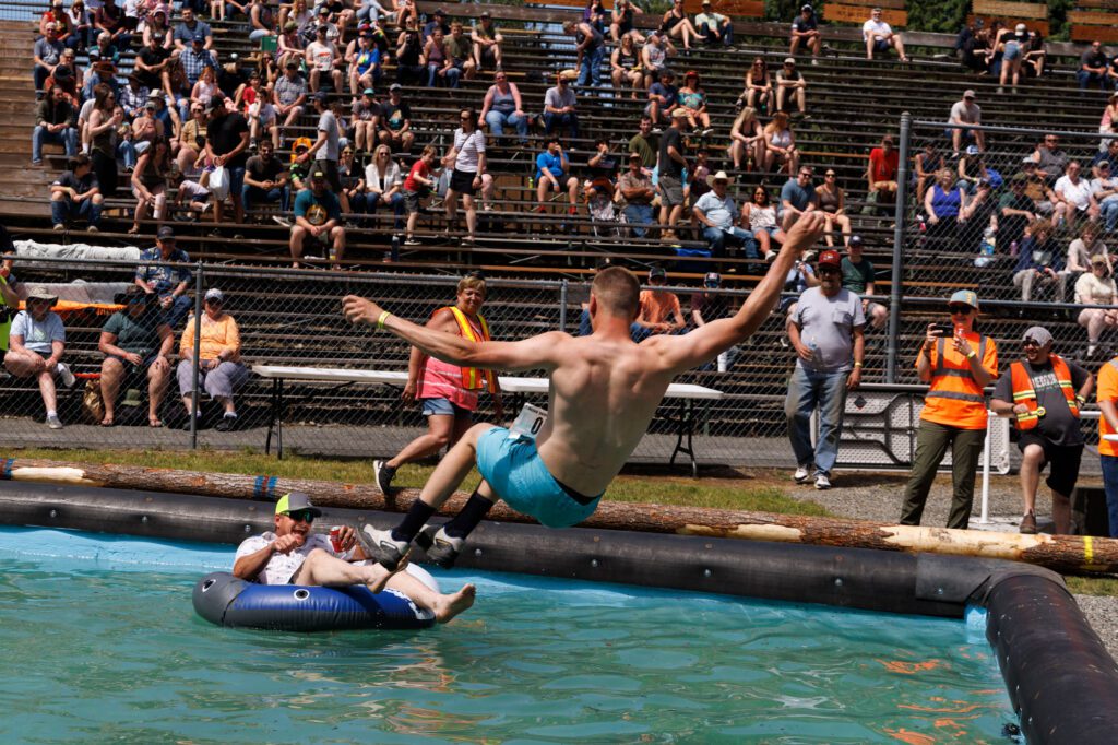 Darren Schmidt jumps in as Jodie Compton tries to lounge in a float in the log-rolling pool.