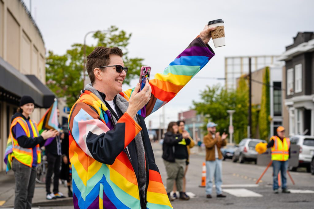 Michelle Harmeier, founder of the Bellingham Queer Collective (BQC), cheers on the Whatcom Youth Pride parade from the sidelines. BQC was one of several community organizations to "adopt a block" during the event.